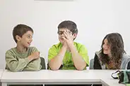 Niños interactúan y se ríen durante actividad en clase de inglés
