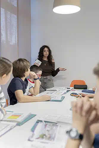 Clase de inglés con niños y profesora guiando la actividad